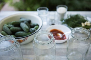 Kış için salatalık turşusunu koruma süreci. Korunmak için gereken malzemeler: dereotu, sarımsak, acı biber, ketçap, tuz, şeker, sirke ve salatalık turşusu için hazırlanır.