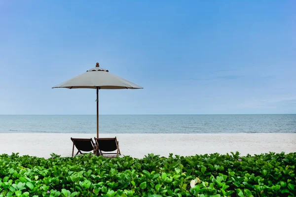 Dwa krzesła plażowe i parasol na tropikalnej plaży. — Zdjęcie stockowe