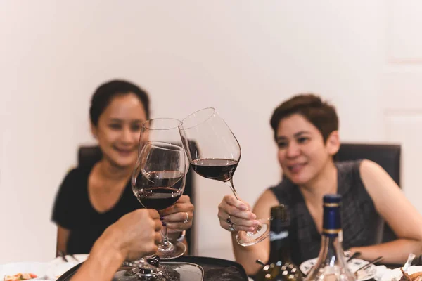 Amigos felices animando con copas de vino tinto en casa . —  Fotos de Stock