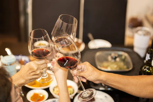 Family toasting with glasses of red wine at dinner party. — Stock Photo, Image