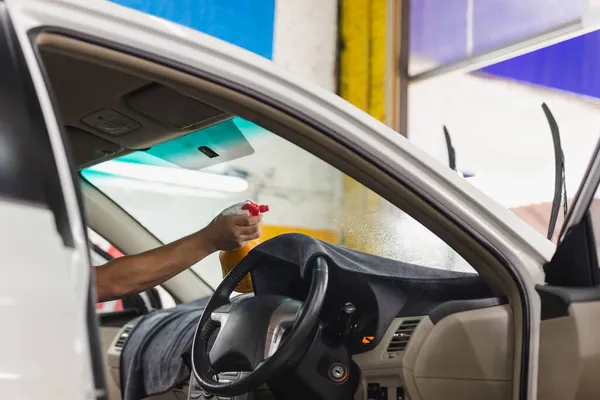 Man specialist sproeien water in getint autoraam in garage. — Stockfoto