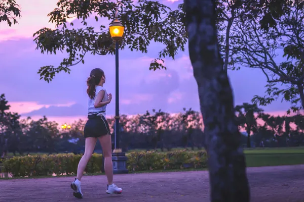 Mulher exercício jogging no parque ao pôr-do-sol fundo. — Fotografia de Stock