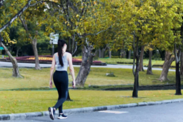 Concepto borroso de mujer caminando en el parque concepto de cuidado de la salud. — Foto de Stock