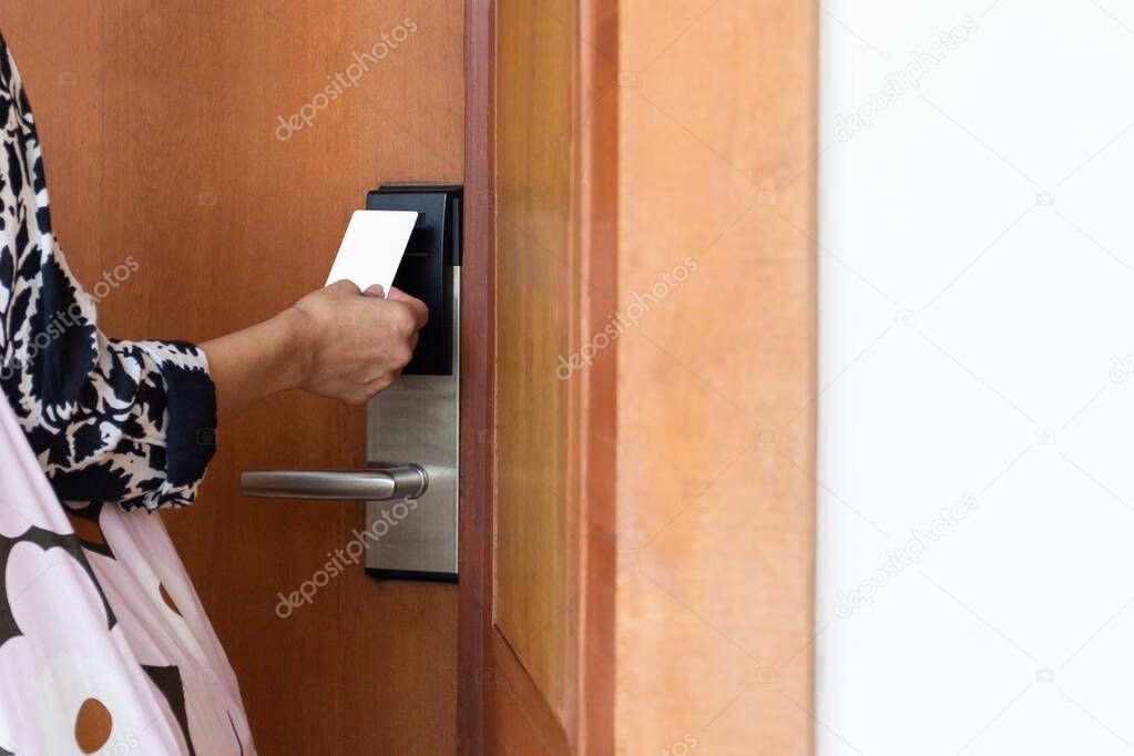 Womans open hotel room with electronic key card.