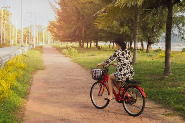 Woman riding bicycle on bike lane outdoors on seaside.. — Stockfoto