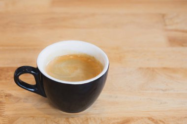 Tahta masada siyah fincanda sade kahve..