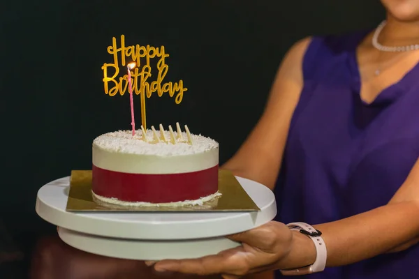 Mujer sosteniendo pastel de cumpleaños con vela y plato de cumpleaños. —  Fotos de Stock