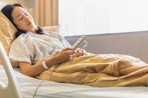 Mujer paciente mano usando control remoto para ajustar el nivel de la cama en el hospital. — Foto de Stock