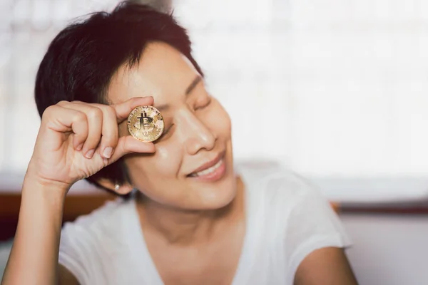Mujer exitosa sosteniendo bitcoin de oro en su mano. —  Fotos de Stock
