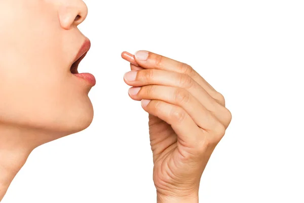 Immagine ravvicinata della donna con la bocca aperta che prende la capsula di vitamina isolata su sfondo bianco. Immagini Stock Royalty Free