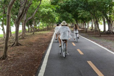 Bulanık konsept grubu parkta bisiklet süren genç bir kadın.