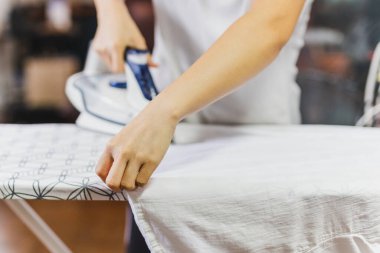 Housewife ironing clothes on an ironing board