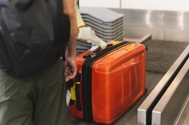 Employee puts tag on passengers luggage at the airport