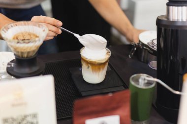 Barista kafede el kremalı buzlu latte kahve yapıyor.