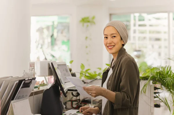 Woman restaurant owner standing at counter receiving orders