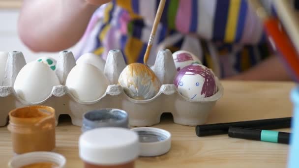 Közelkép a lány színező húsvéti tojás otthon segítségével festékek és ecset. — Stock videók