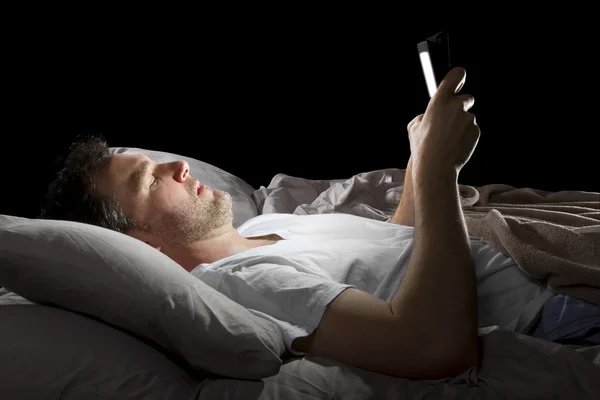 Homme au lit avec une tablette — Photo