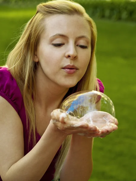 Счастливая девушка, пускающая мыльные пузыри — стоковое фото