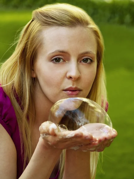 Happy girl blowing soap bubbles — Stock Photo, Image