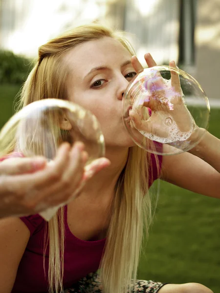 Happy girl blowing soap bubbles — Stock Photo, Image