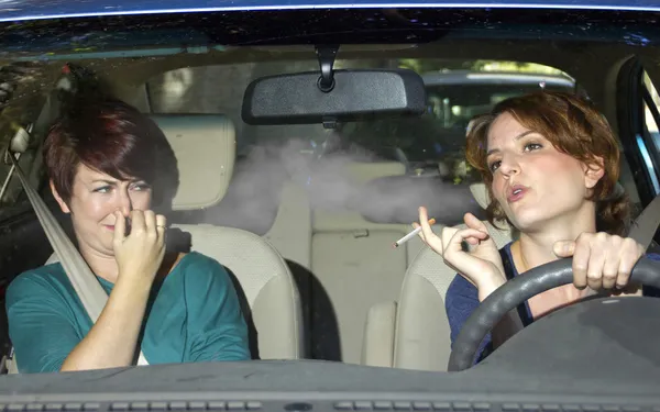 Mulher fumando enquanto dirige dentro do carro — Fotografia de Stock