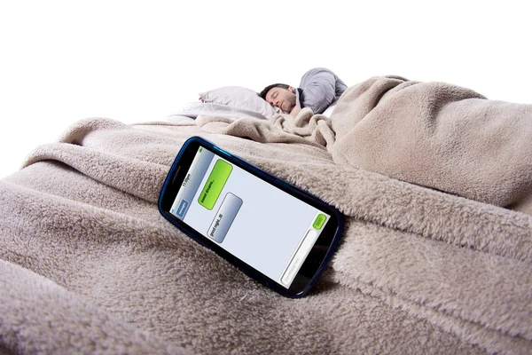 Scherm van de mobiele telefoon toont tekstberichten terwijl man is in bed — Stockfoto