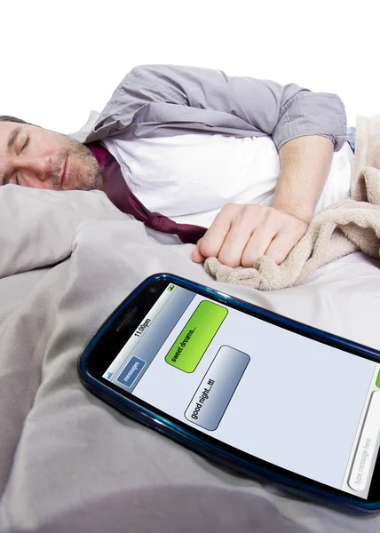 Cell phone screen showing text messages while male is in bed — Stock Photo, Image