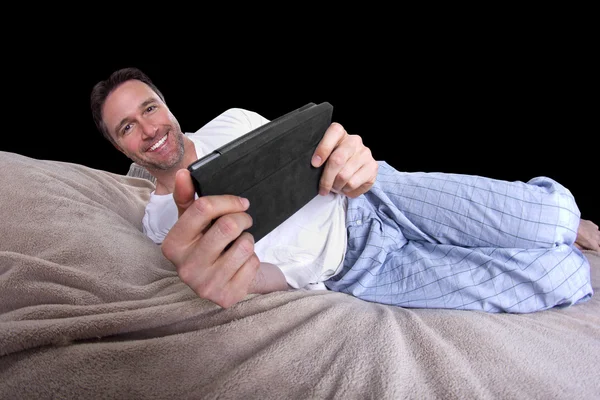Man läser på en tablett innan du går att sova — Stockfoto
