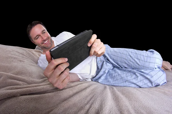 Male reading on a tablet before going to sleep — Stock Photo, Image