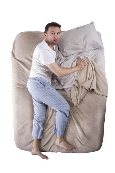 Sleep deprived man on a bed — Stock Photo, Image