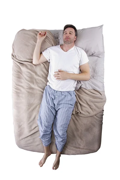 Sleep deprived man on a bed — Stock Photo, Image