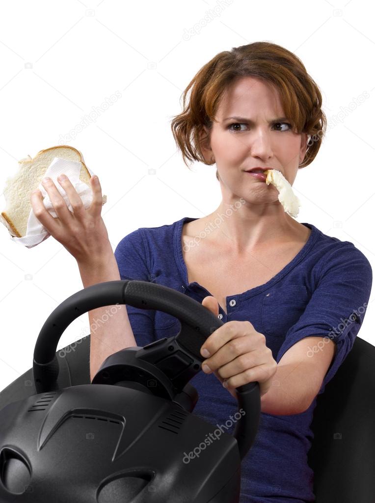Woman eating a sandwich while driving