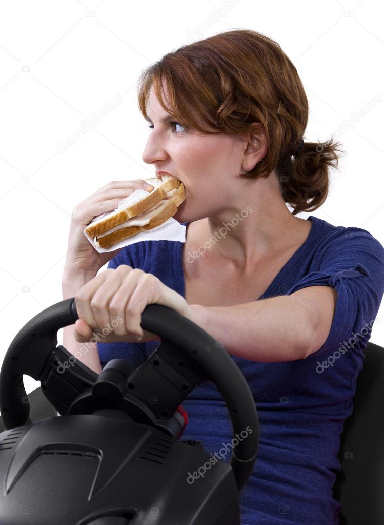 Woman eating a sandwich while driving