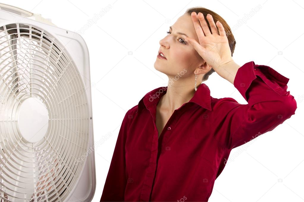 Businesswoman cooling off with a fan