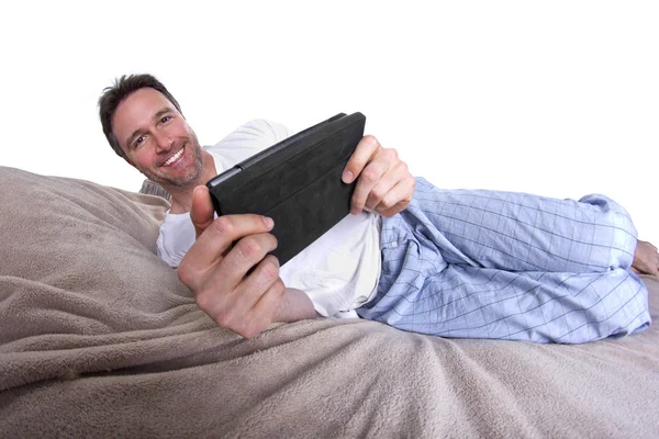 Leitura masculina em um comprimido antes de ir dormir — Fotografia de Stock