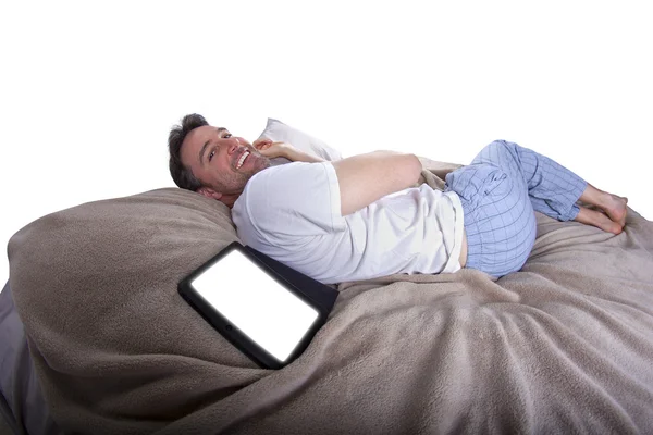 Leitura masculina em um comprimido antes de ir dormir — Fotografia de Stock