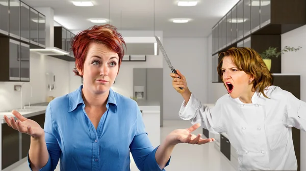 Chef and waitress fighting in the kitchen — Stock Photo, Image