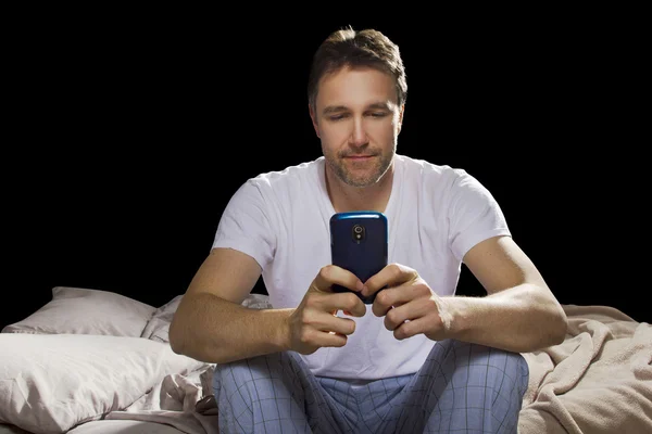 Homem no quarto usando telefone celular — Fotografia de Stock