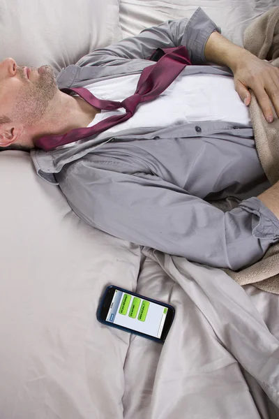 L'uomo dorme e ricezione di messaggi di testo dal lavoro — Stockfoto