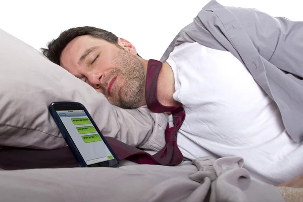 Чоловік спить і отримує текстові повідомлення від роботи — стокове фото