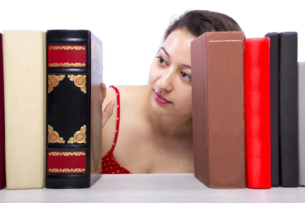 Frau liest Bücher aus Bücherregal — Stockfoto