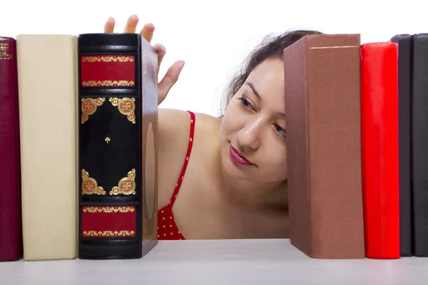 Vrouw lezen van boeken uit boekenplank — Stockfoto