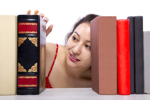 Vrouw lezen van boeken uit boekenplank — Stockfoto