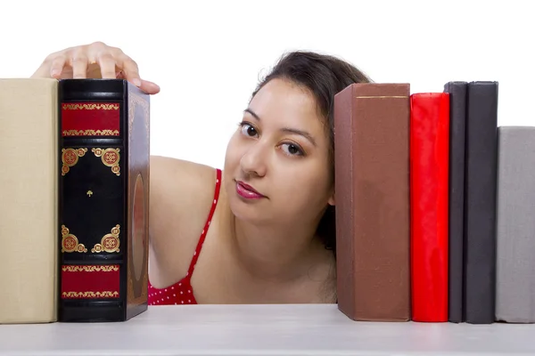 Vrouw lezen van boeken uit boekenplank — Stockfoto