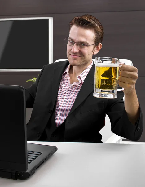 Businessman with laptop and beer — Stock Photo, Image