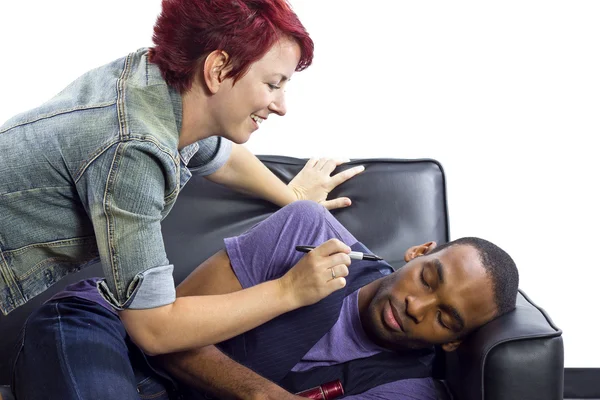 Mujer dibujando en la cara de un amigo — Foto de Stock