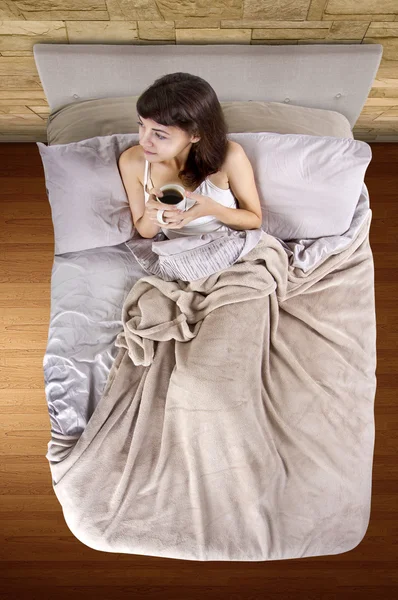 Mujer tomando café en la cama por la mañana —  Fotos de Stock