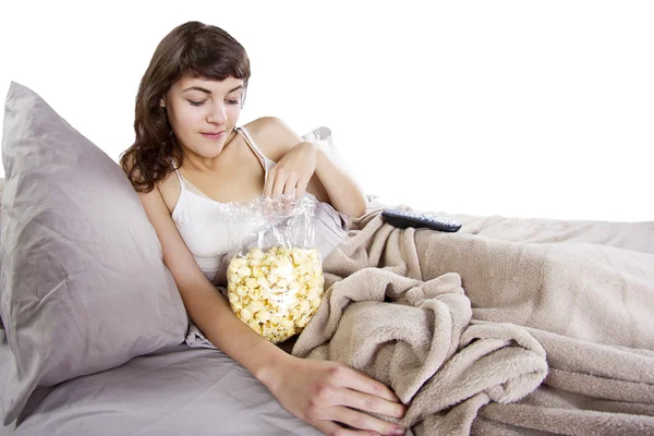 Adolescente viendo películas en la cama con palomitas de maíz —  Fotos de Stock