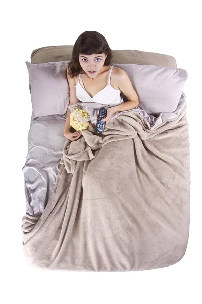 Tinédzser filmeket néz az ágyban, a pattogatott kukorica — Stock Fotó