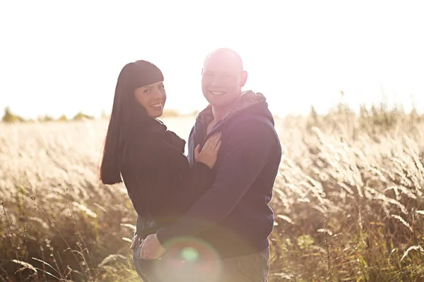 Joyeux jeune couple dans un champ — Photo